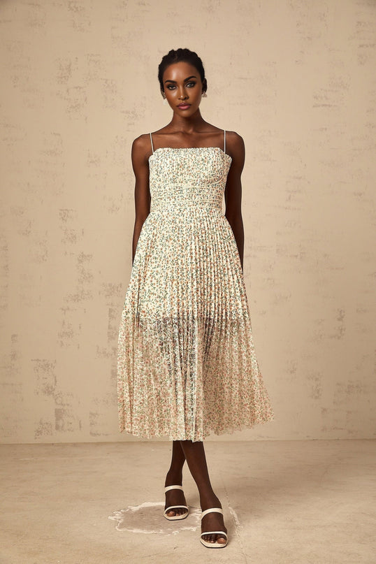 A white midi dress with a floral print pattern and pleated design featuring a feminine silhouette and delicate details