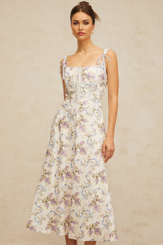 A white midi dress with a floral print pattern featuring a flared skirt design and Bruyere branding