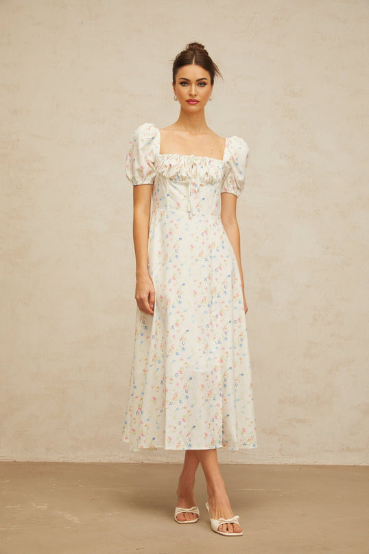 A white midi dress with a floral print pattern featuring a flared skirt design and named Eva