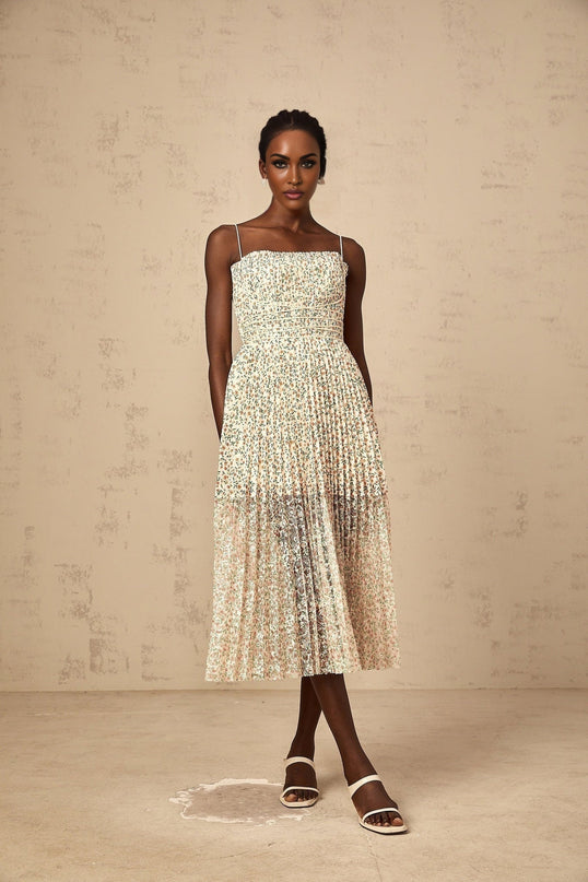 A white midi dress with a floral print pattern featuring pleats and a feminine silhouette named Marion