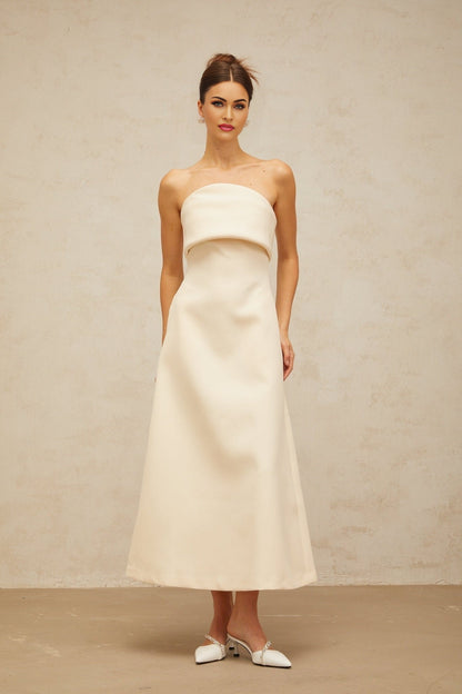 A white midi dress with a folded corset style bodice and a fitted silhouette named Raphaelle