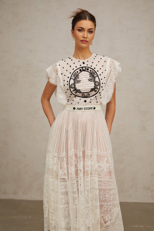A white midi dress with a jacquard floral lace pattern featuring pleats and a delicate Phoebe design