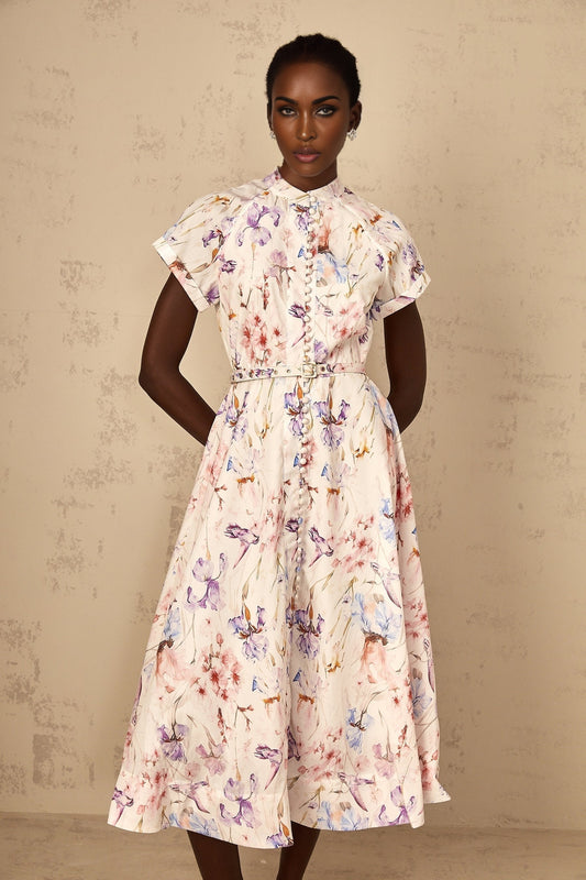 A white midi dress with a mock neck and floral print worn by a woman named Geraldine