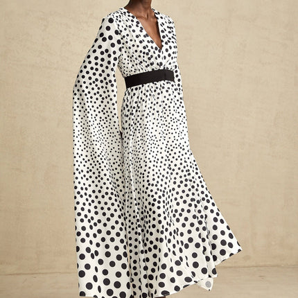 A white midi dress with black polka dots featuring slit sleeves and a fitted silhouette