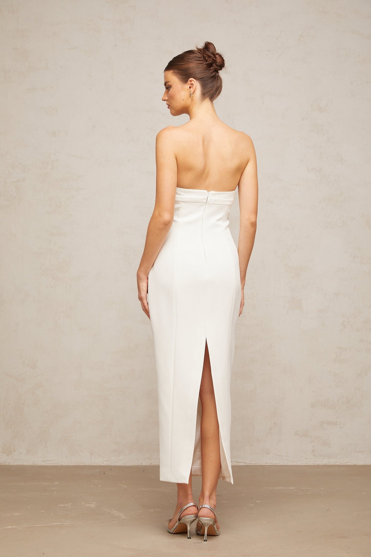 A white midi dress with corset styling and bow details named Isaline