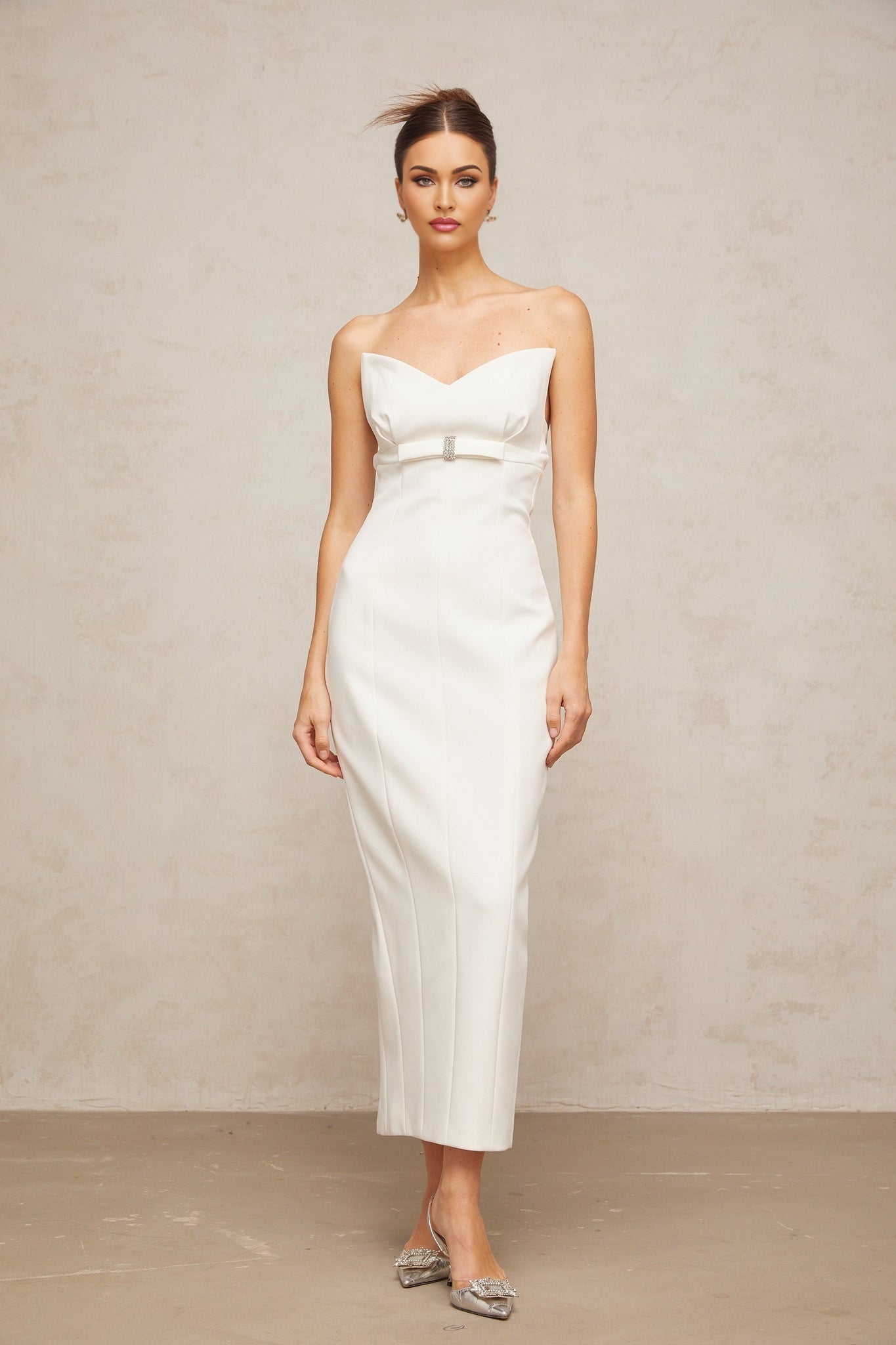 A white midi dress with corsetstyle bodice and bow detail named Isaline