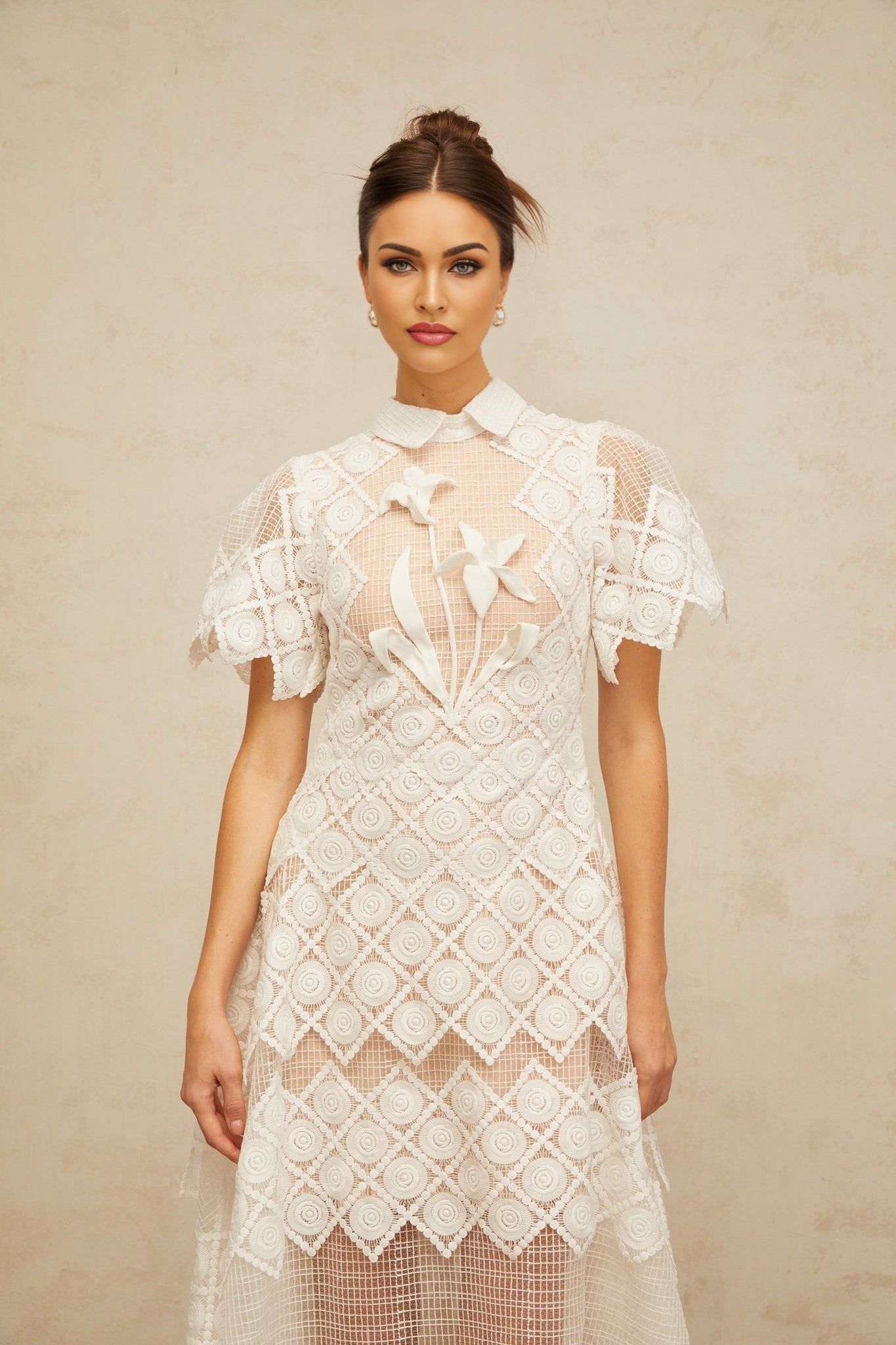 A white midi dress with delicate floral embroidery named Yasmine featuring a feminine silhouette and intricate stitching details