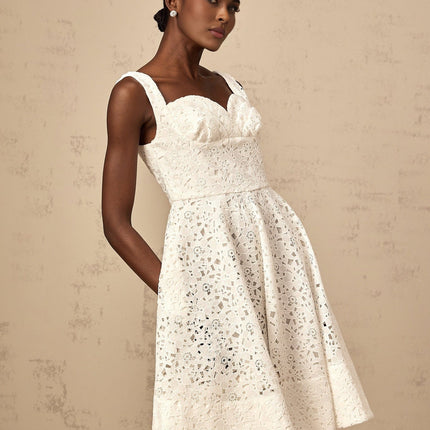 A white midi dress with delicate floral lace pattern featuring a feminine silhouette and romantic design details