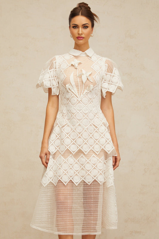 A white midi dress with floral embroidery detailing named Yasmine