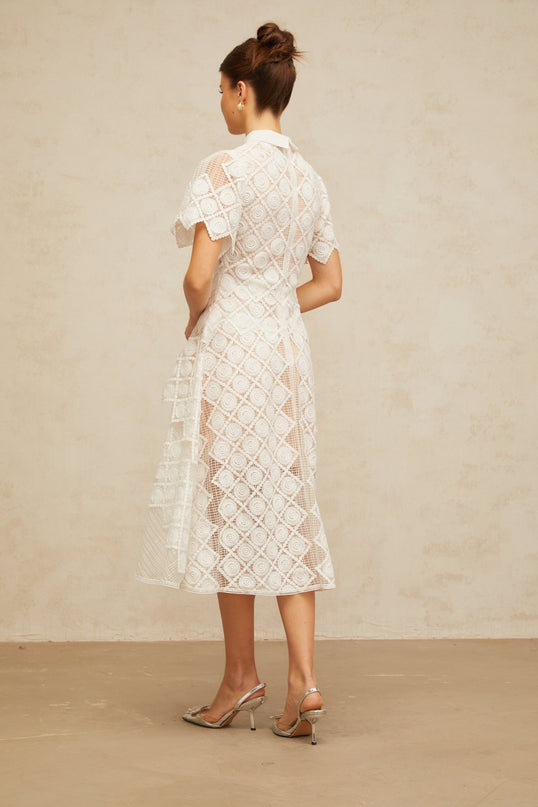 A white midi dress with floral embroidery featuring a design called Yasmine