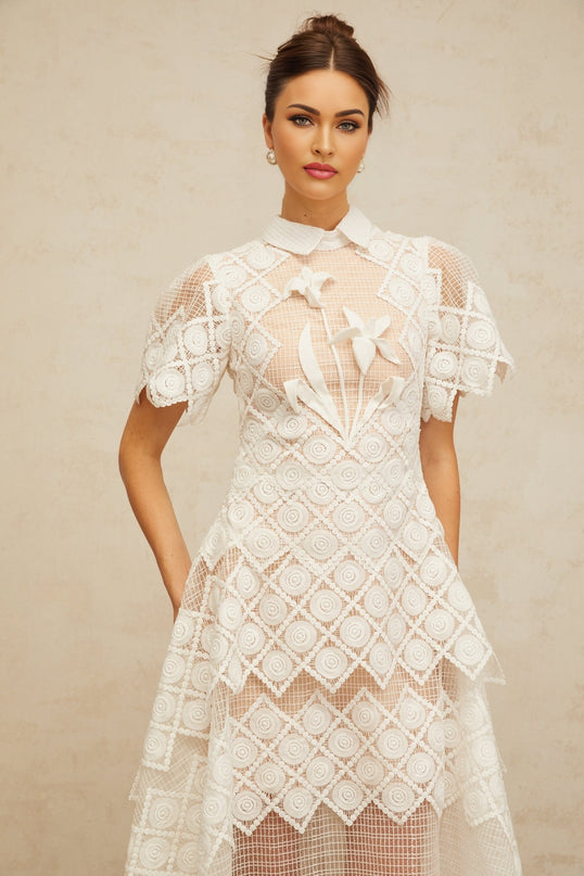 A white midi dress with floral embroidery featuring a design called Yasmine
