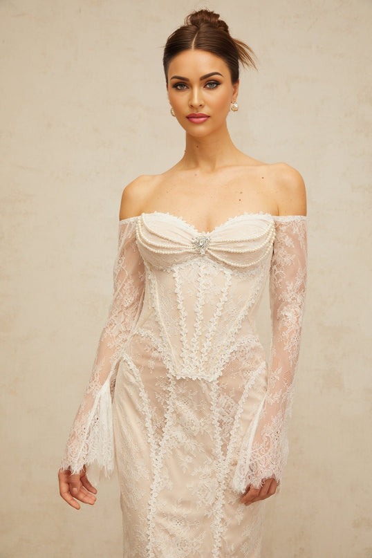 A white midi dress with floral lace embellishments and delicate detailing named Enora