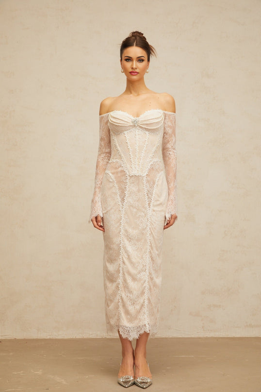 A white midi dress with floral lace embellishments and intricate detailing named Enora