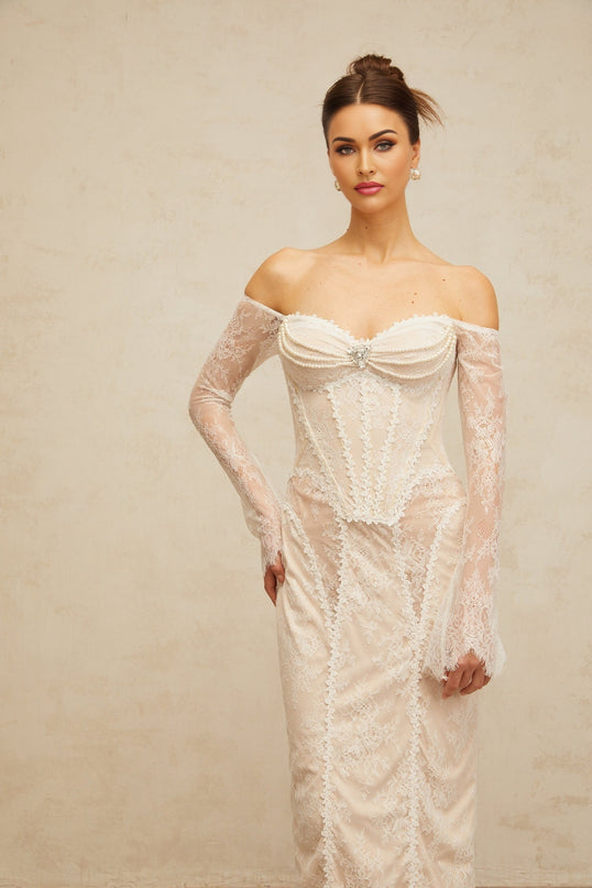 A white midi dress with floral lace embellishments and intricate detailing named Enora