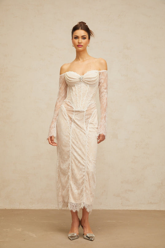 A white midi dress with floral lace embellishments and intricate embroidery details covering the bodice and skirt