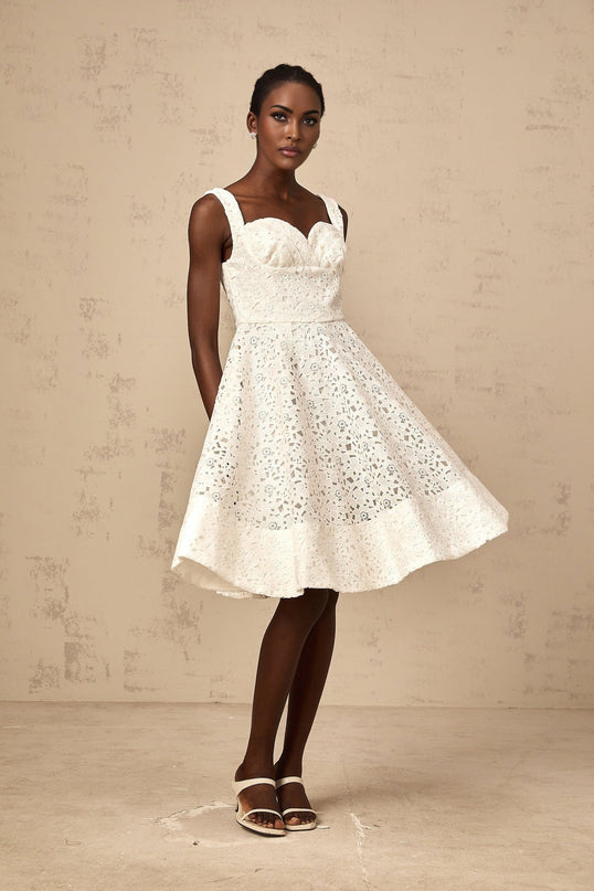 A white midi dress with floral lace pattern featuring a fitted bodice and flowing skirt