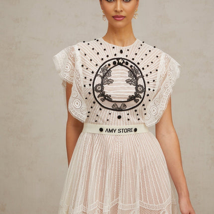 A white midi dress with jacquard floral lace pattern featuring pleated design and named Phoebe