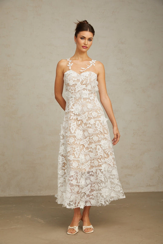 A white midi dress with lace detailing and tulle panels featuring a delicate and feminine design