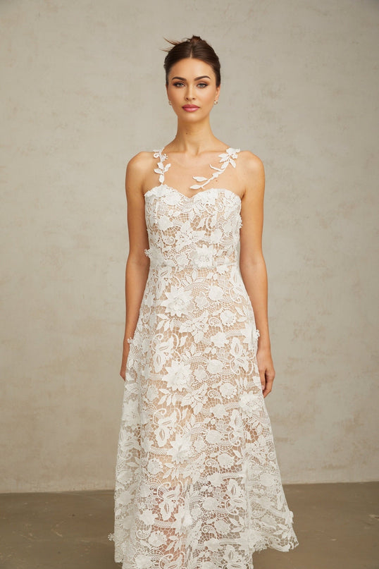 A white midi dress with lace detailing and tulle panels featuring a delicate feminine design