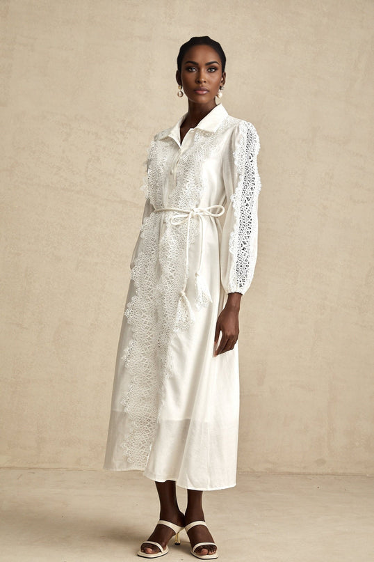 A white midi dress with lace details and a tied waist named Colette