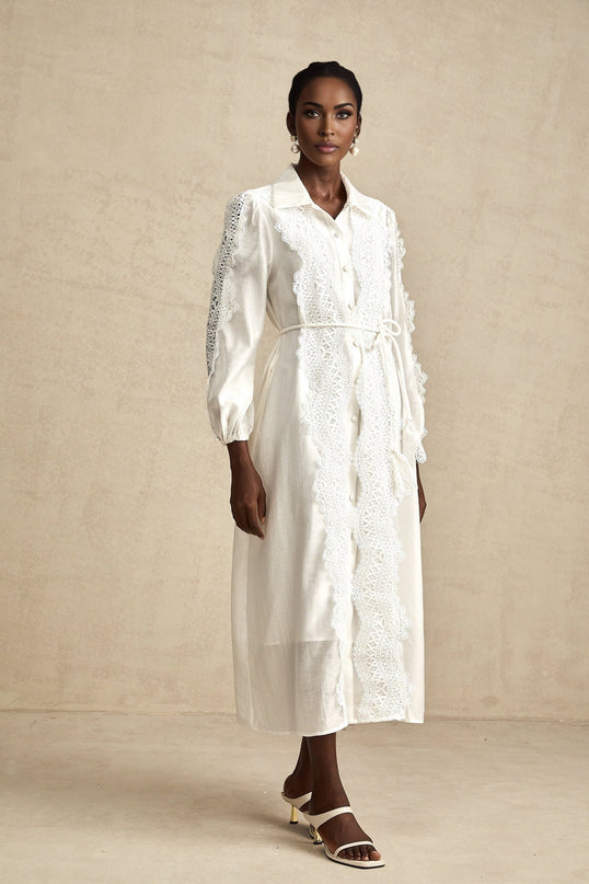 A white midi dress with lace details and a tied waist named Colette