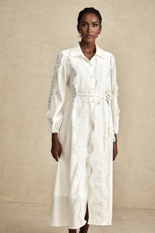 A white midi dress with lace details and a tied waist named Colette