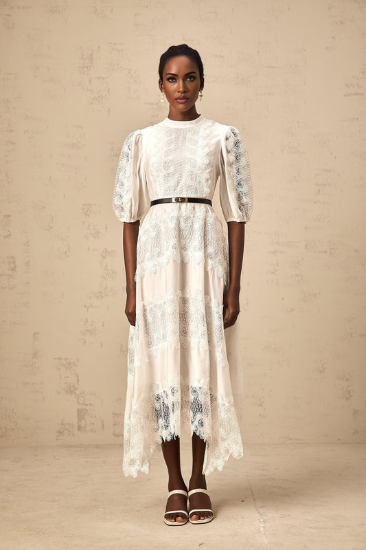 A white midi dress with lace trim panels and a belt at the waist featuring a sleeveless design and a flowy skirt