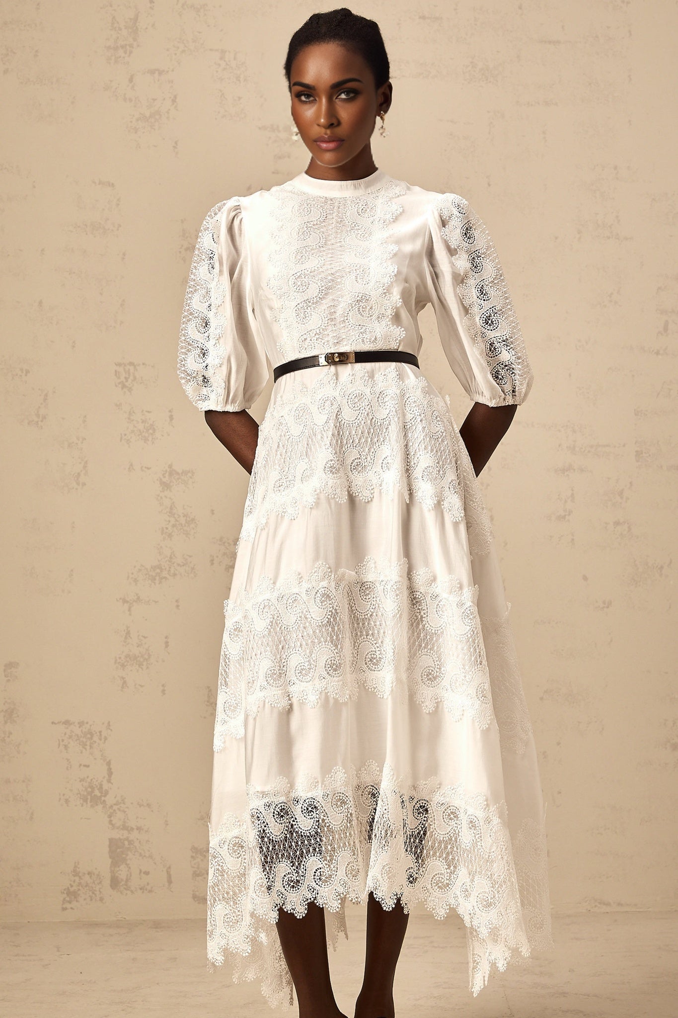 A white midi dress with lace trim panels and a belt at the waist