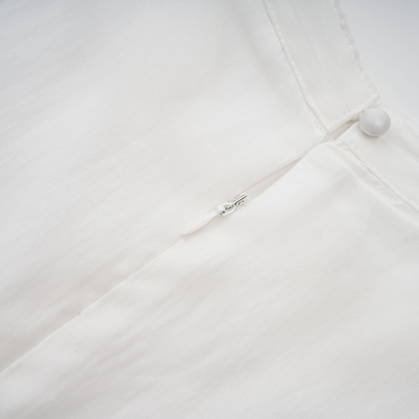 A white midi dress with lace trim panels and a belted waist named Tamara