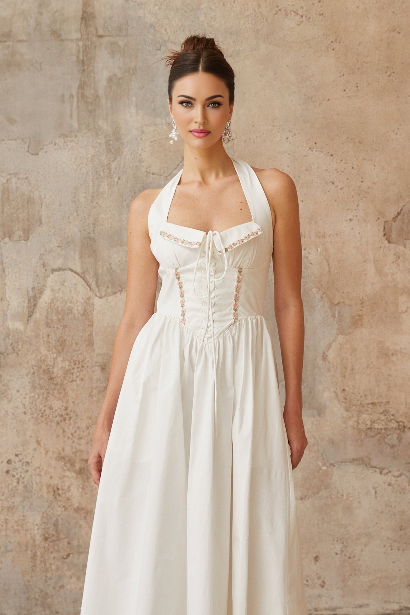 A white midi dress with laceup detailing and shirred fabric featuring a feminine silhouette and delicate design elements