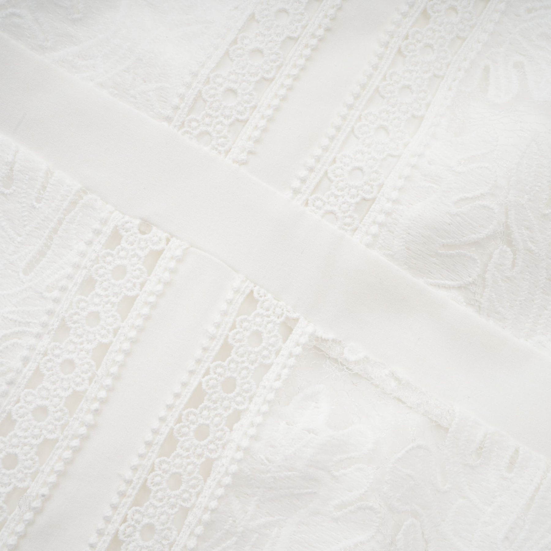A white midi dress with panelled design and embroidery details named Madeleine featuring a feminine silhouette and delicate pattern work