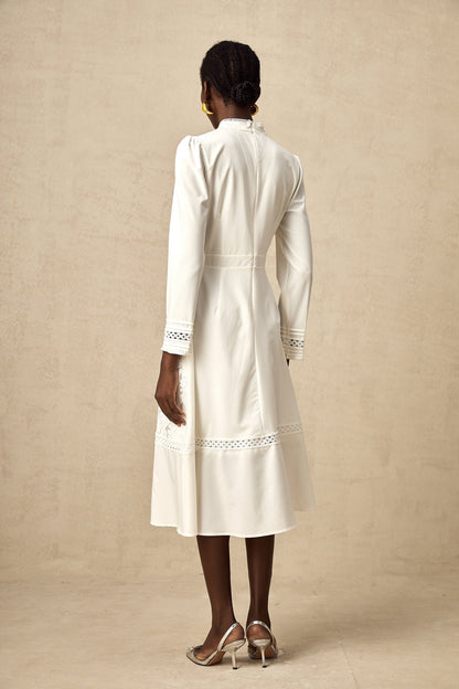 A white midi dress with panelled design and embroidery details named Madeleine featuring a feminine silhouette and delicate stitching throughout