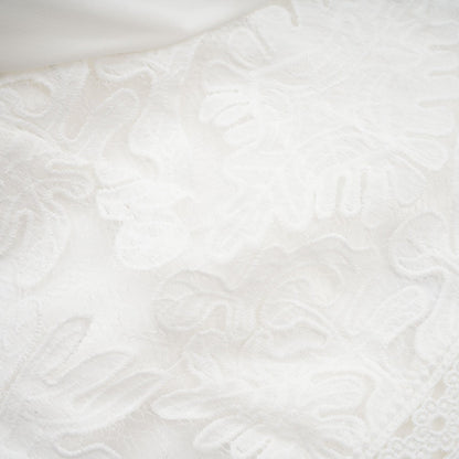 A white midi dress with panelled design and embroidery details named Madeleine featuring a fitted bodice and flowy skirt