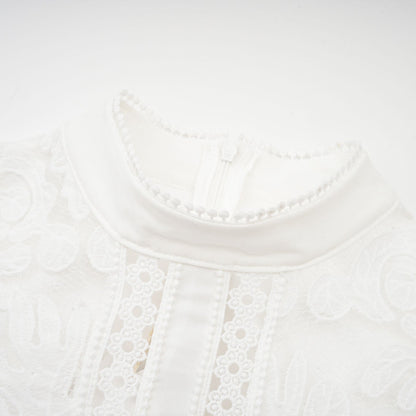A white midi dress with panelled design and embroidery details named Madeleine featuring a fitted silhouette and delicate floral patterns
