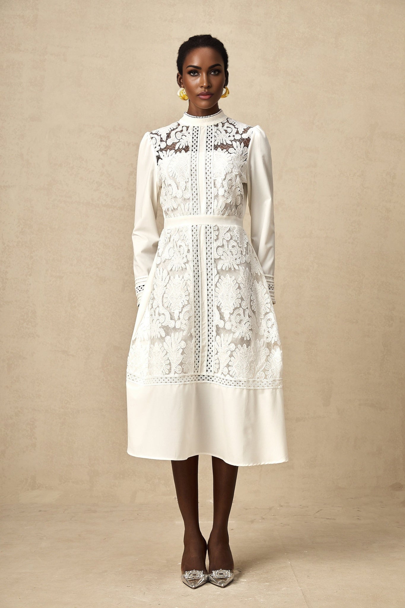 A white midi dress with panelled design and embroidery details named Madeleine featuring a fitted silhouette and delicate stitching patterns