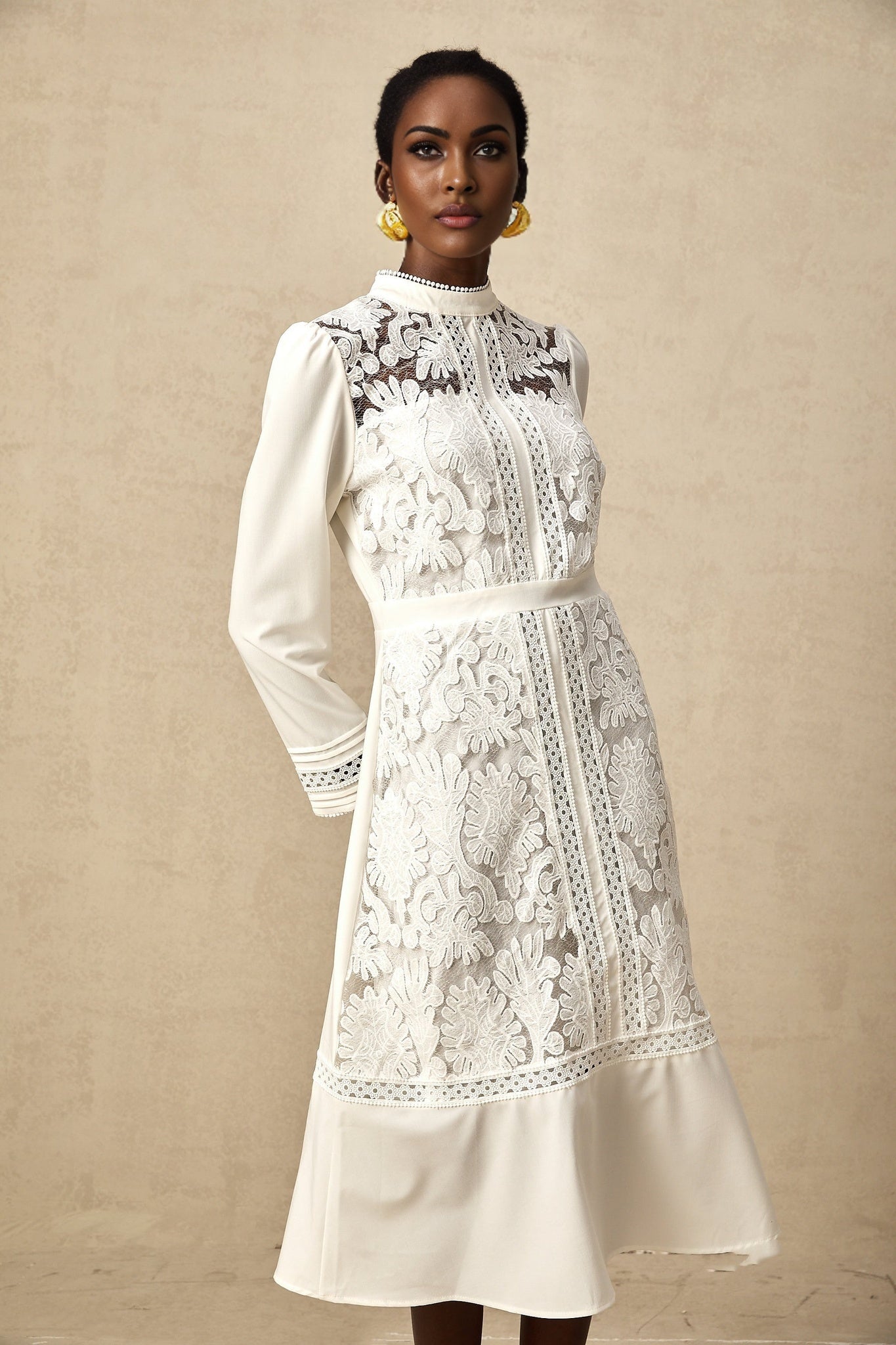 A white midi dress with panelled design and embroidery details named Madeleine featuring a fitted silhouette and feminine aesthetic
