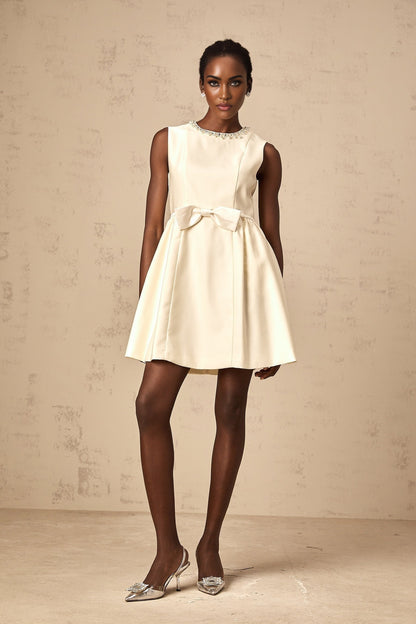 A white mini dress with a bow detail named Isabelle