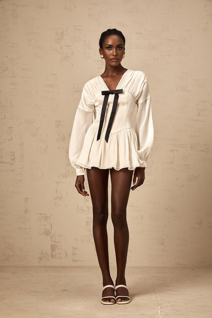 A white mini dress with a bowknot detail and glitter accents named Lina