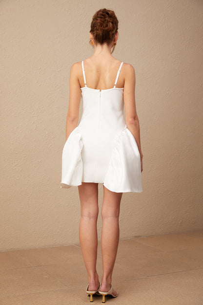 A white mini dress with a bustier style top featuring a delicate floral pattern throughout the fabric