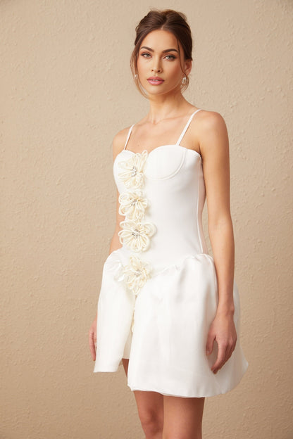 A white mini dress with a bustier top featuring a floral motif pattern throughout the fabric