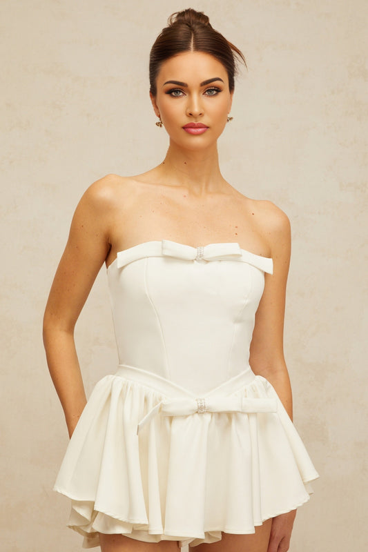 A white mini dress with a corsetstyle bodice featuring a bowknot detail at the front named Ariel