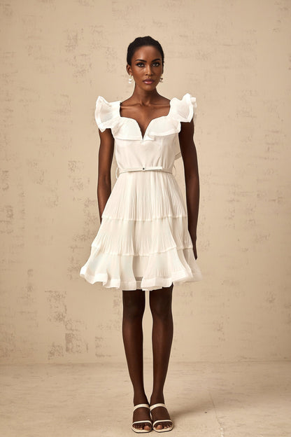 A white mini dress with a frilled neckline and pleated design named Éliane