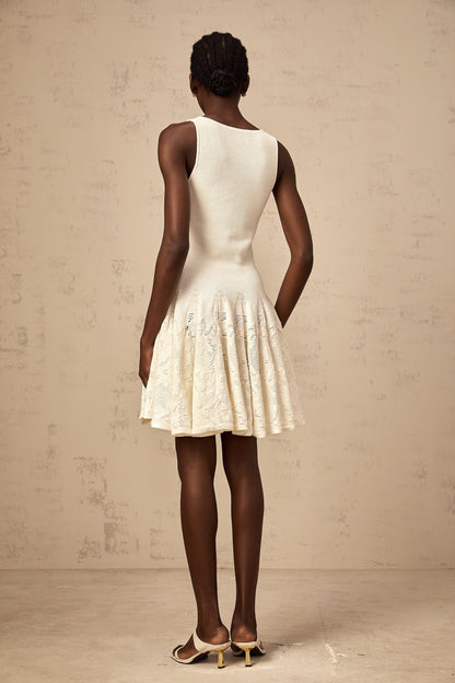 A white mini dress with a jacquard knit pattern featuring a short hemline and textured fabric design