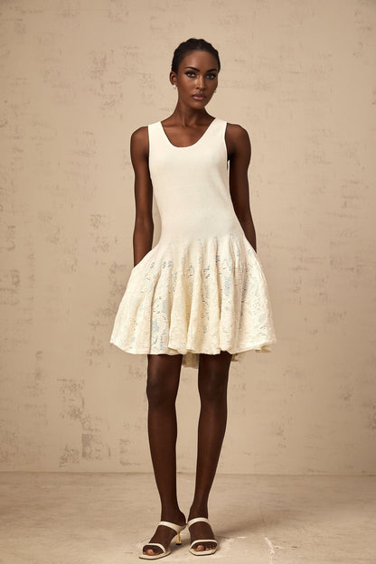A white mini dress with a jacquard knit pattern named Eleonore worn by a model standing against a plain background