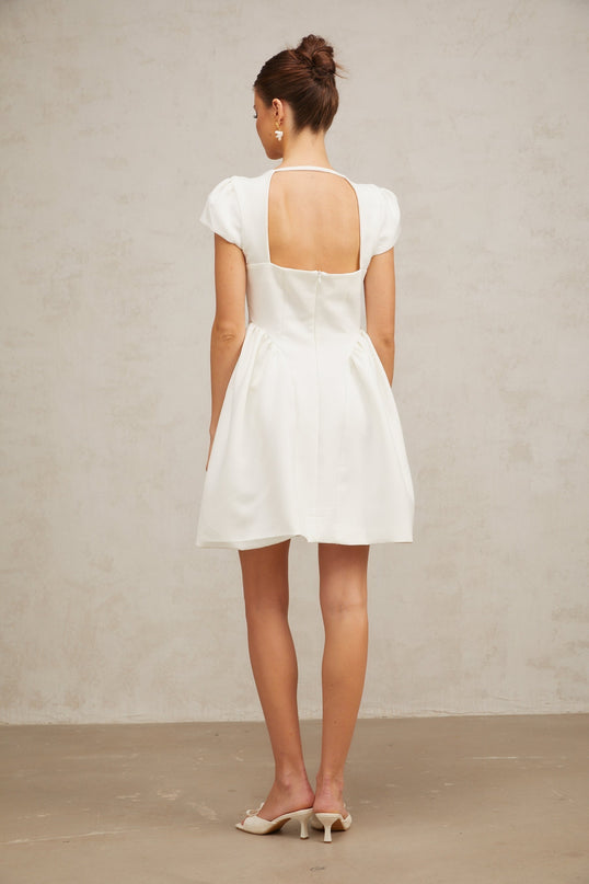 A white mini dress with cap sleeves featuring a fitted silhouette and a short hemline named Raphaela