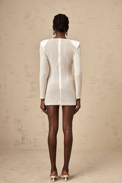 A white mini dress with cutout details and a decorative bowknot embellishment