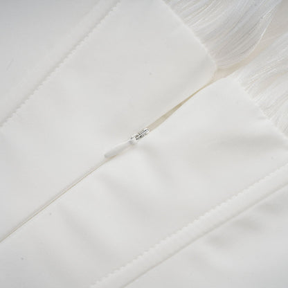 A white mini dress with full pleating and a cinched waist featuring a rosier design