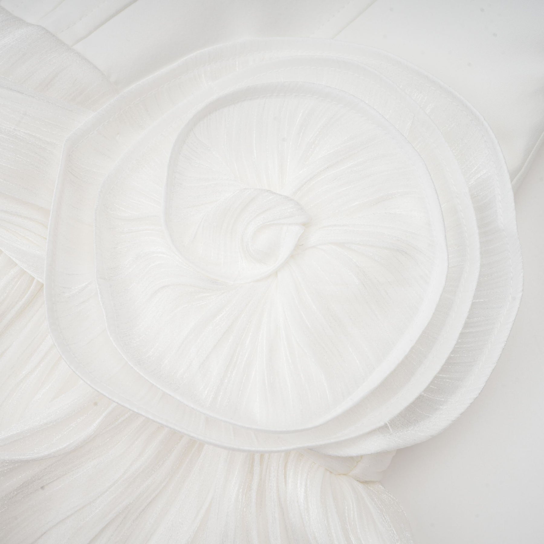 A white mini dress with full pleats and a cinched waist design featuring a rosier style and short length