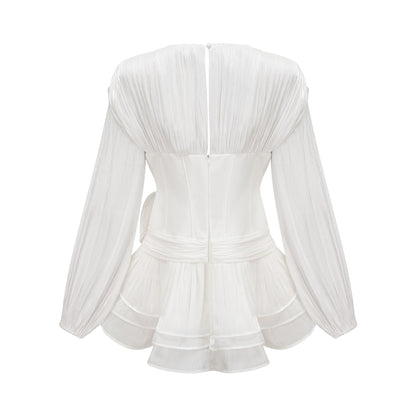 A white mini dress with full pleats and a cinched waist featuring a rosier design