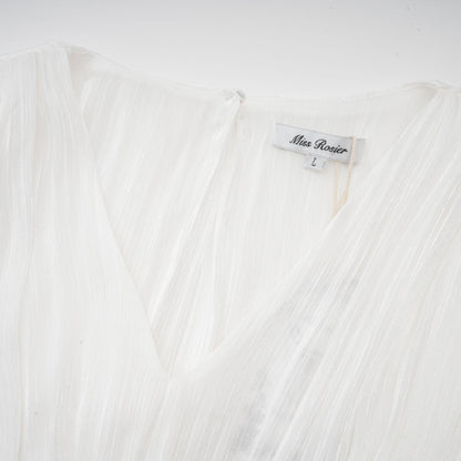 A white mini dress with full pleats and a cinched waist featuring a rosier design